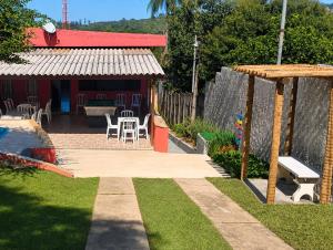 a backyard with a table and chairs and a house at Estação lazer e Eventos in Mairinque
