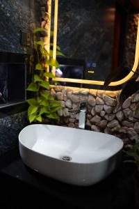 a white sink in a bathroom with a stone wall at Ro Cabin in Ella +58 photos