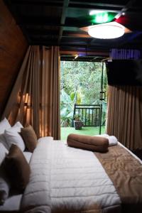 a bedroom with two beds and a large window at Ro Cabin in Ella