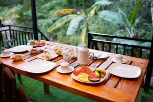 a wooden table with plates of food on it at Ro Cabin in Ella