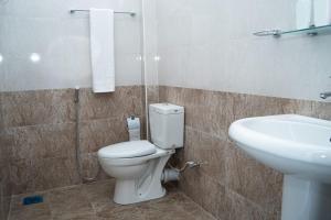 a bathroom with a toilet and a sink at Rainforest White House in Deniyaya
