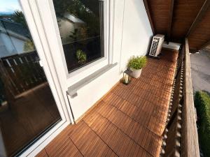 an outdoor deck with a window and potted plants at Apartment 98 - 2 Schlafzimmer, Balkon & Vogelsbergblick in Hungen +5 photos