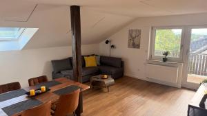 a living room with a couch and a table at Apartment 98 - 2 Schlafzimmer, Balkon & Vogelsbergblick in Hungen