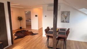 a dining room with a table and a tree stump on the floor at Apartment 98 - 2 Schlafzimmer, Balkon & Vogelsbergblick in Hungen