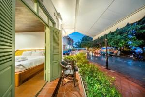 a bedroom with a bed and a view of a street at Nava Luang Prabang Hotel in Luang Prabang