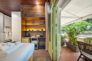 a room with a bed and a desk in it at Nava Luang Prabang Hotel in Luang Prabang