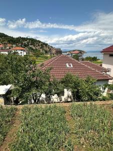 a white house with a red roof and trees at The Grandparent's House in Piskupat