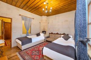 a bedroom with two beds and a fireplace at Duven Hotel Cappadocia in Uçhisar