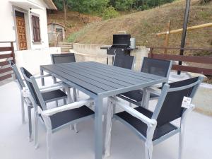 a picnic table with four chairs and a grill at Nidus in Aulla