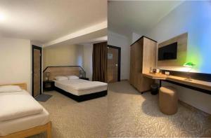 two pictures of a hotel room with two beds at Hotel Fluss Oase - Feldschlößchen in Weißenfels