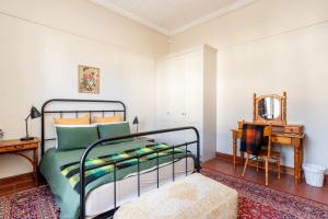 a bedroom with a bed and a table and a mirror at Elizabeth's Cottage in Montagu