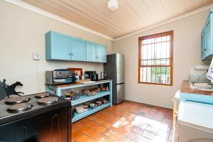 a kitchen with a stove and a refrigerator at Elizabeth's Cottage in Montagu