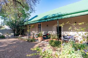 a house with a green roof and a patio at Elizabeth's Cottage in Montagu