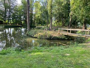 a wooden bridge over a river in a park at Lys in Gury