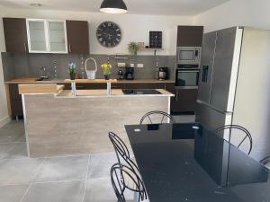 a kitchen with a table and chairs and a refrigerator at Lys in Gury