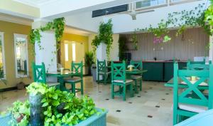 ein Restaurant mit blauen Tischen und Stühlen und Pflanzen in der Unterkunft Hotel Checkin El Cortecito in Punta Cana