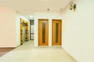 a hallway with wooden doors on a white wall at FabHotel Aayansh in Jaipur