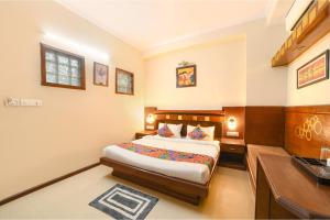 a bedroom with a bed and a desk in it at FabHotel Aayansh in Jaipur