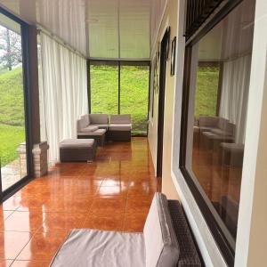 a hallway with a living room with couches and windows at Villa Gonz in Río Cuarto