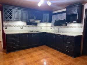 a kitchen with navy blue cabinets and white counter tops at Villa Gonz in Río Cuarto