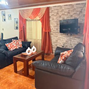 a living room with two couches and a tv at Villa Gonz in Río Cuarto