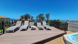 a bunch of chairs sitting on a deck next to the water at #7 Illovo Views in Kingsborough