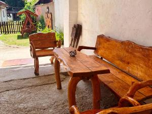 a wooden bench and a table with a cat sitting on it at Apartmán Arkona in Slovenská ľupča