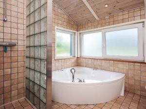 a bath tub in a tiled bathroom with a window at 4 star holiday home in Tarm in Tarm +38 photos