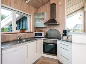 a kitchen with white cabinets and a sink at 4 star holiday home in Tarm in Tarm