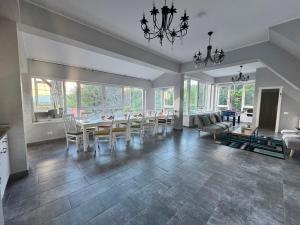 a dining room with a table and chairs and a living room at Premont Bran GuestHouse in Bran