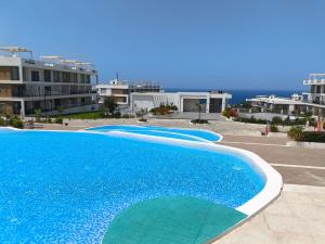 a large blue swimming pool with buildings in the background at Luxury Sea & Pool View Apt at Caesar Cliff Esentepe in Perivolia tou Trikomou