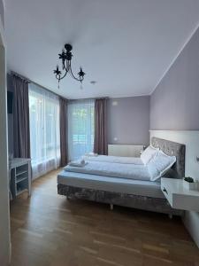 a bedroom with a large bed and a chandelier at Premont Bran GuestHouse in Bran