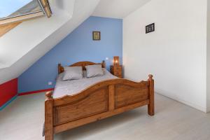 a bedroom with a wooden bed with a blue wall at Maison La Plouhinecoise in Plouhinec