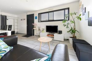 a living room with a couch and a tv at Maison La Plouhinecoise in Plouhinec