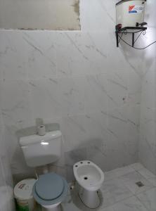 a white bathroom with a toilet and a sink at Alojamiento Lidia in Iruya +9 photos