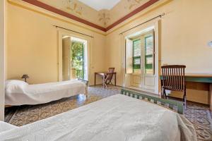a bedroom with two beds and a window at Villa Charme Lipari in Lipari