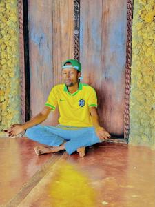 a man sitting on the floor in front of a door at Triple A visitors in Kilindoni