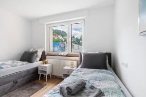 a bedroom with two beds and a window at Apartment Melody in Oberkochen