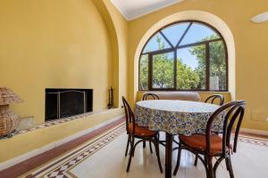 a dining room with a table and chairs and a fireplace at Villa Charme Lipari in Lipari