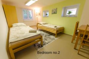 a bedroom with two beds and a table and a table at Prízemný apartmán Anika s veľkým parkovaním in Nitra