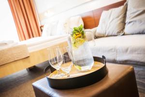 a tray with two glasses and a vase on a table at Hotel Osrblie in Osrblie +67 photos