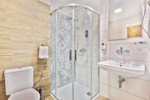 a bathroom with a shower and a toilet and a sink at Hotel Osrblie in Osrblie