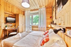 a bedroom with a bed and a desk and a window at Hotel Osrblie in Osrblie