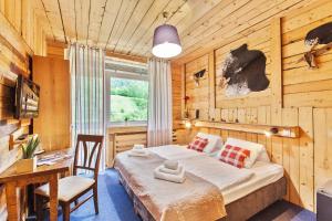 a bedroom with a bed in a wooden room at Hotel Osrblie in Osrblie