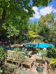 a garden with benches and a swimming pool at Le Clos du Moulin Dijon, piscine, la campagne à la ville, proche centre historique in Dijon