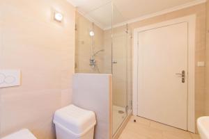 a white bathroom with a toilet and a shower at Ferienwohnung Onkel Toms Hütte in Scharbeutz
