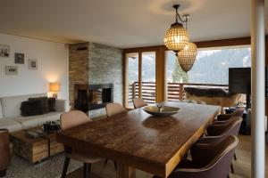 a living room with a dining room table and a couch at Bergwelt Grindelwald - Alpine Design Resort in Grindelwald