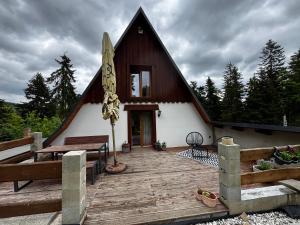 a house with a wooden deck with a bench and a table at U Cejhonů in Měděnec
