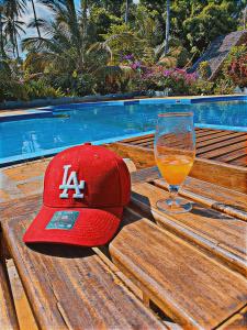 a baseball cap and a glass of beer on a wooden bench at Triple A visitors in Kilindoni