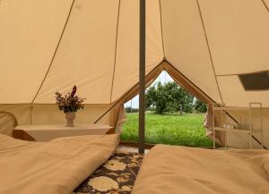 a tent with two beds and a vase with flowers in it at Vallimäe Glamping Otepää in Mägestiku